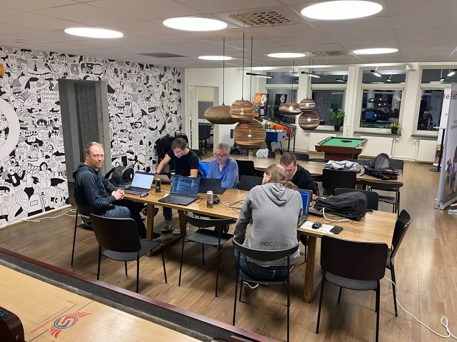Seks konsulenter med bærbare PC-er rundt et langbord i Ensos kontorlokaler under CTF-en