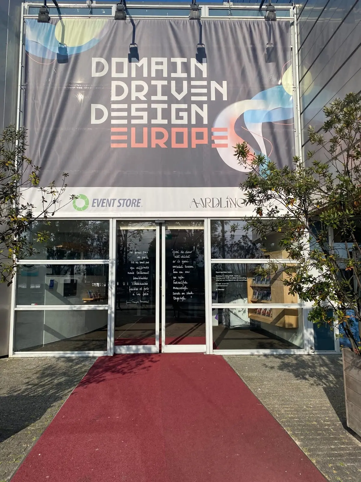 Inngangen til konferansen med et stort Domain Driven Design Europe-banner og rød løper